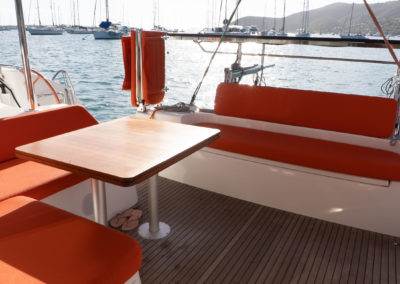 Cockpit de l'Excess 11 avec sellerie Orange et siège de barre repliable au mouillage en Martinique
