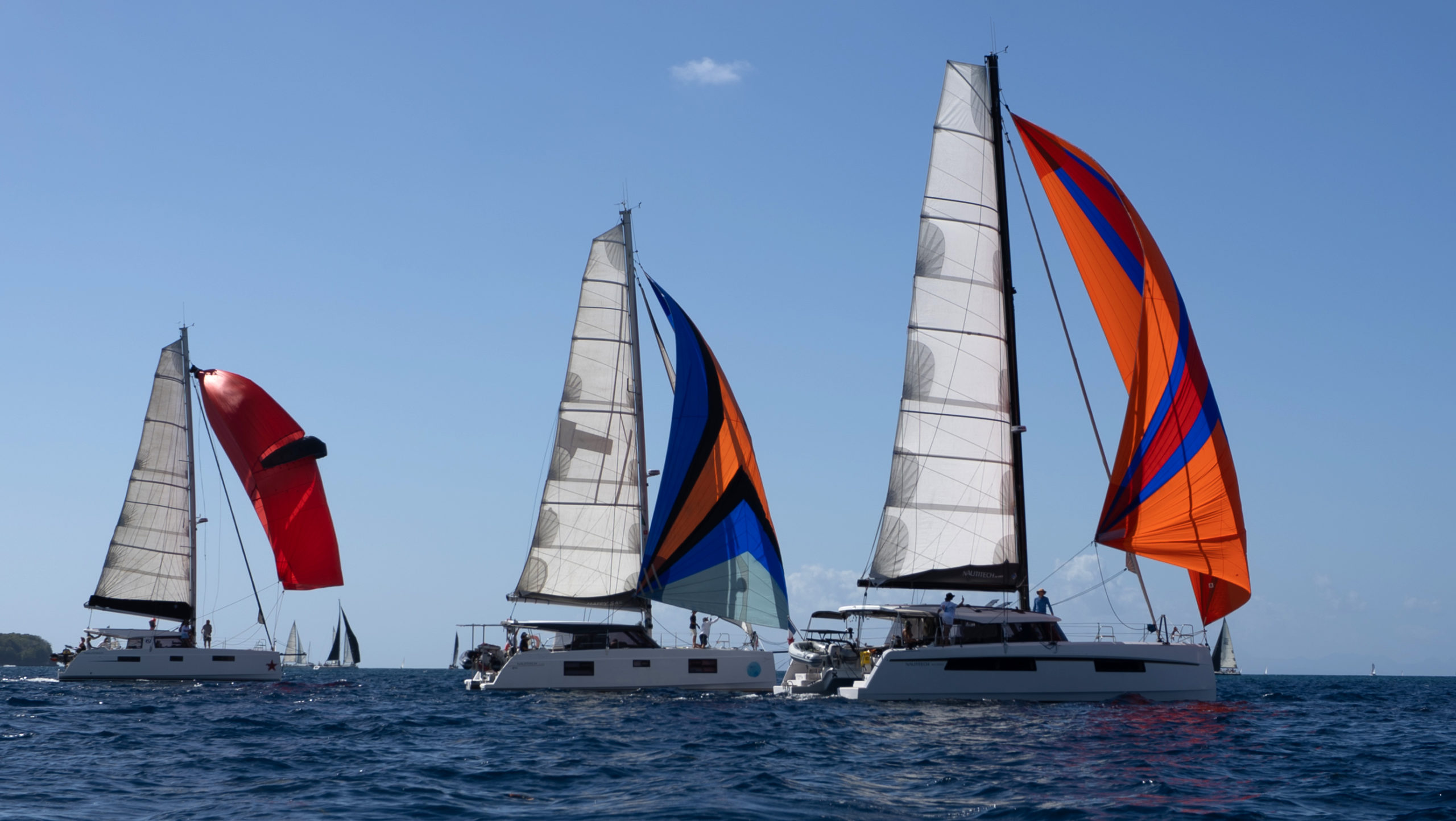 Trois catamarans Nautitech naviguent aux Antilles avec des voiles Delta Voiles et Oxley Sails. 