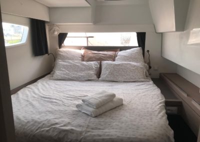 Cabine arrière tribord, coté invité. Grand lit double avec de nombreuses ouvertures, ventilateur, liseuse et chargeur USB. Accès à la salle da bain et les toilettes.