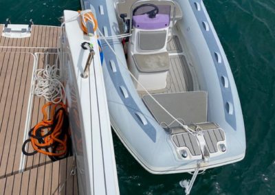 Bordé arrière bâbord du Fountaine Pajot Tanna 47 avec sol en Teck synthétique, plateforme de bain arrière avec echelle de bain et douchette de pont. Annexe Gala avec poste de commande déporté et moteur Suzuki.