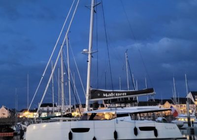 Fountaine Pajot Tanna 47 en vente chez Neo Marine, vu de loin, de nuit amarré dans un port breton.