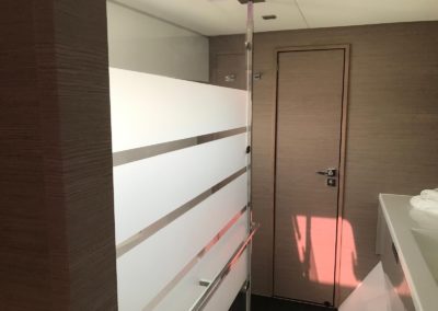 Salle de bain de la cabine propriétaire avec douche à l'italienne et accès aux toilettes séparés.