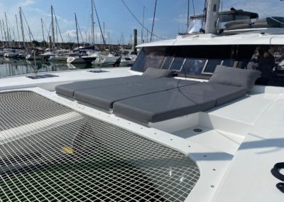 Trampoline et bain de soleil avant sur le Tanna 47. Grand pare brise avec deux ouvrants pour l'aération du bateau. Bimini de protection du poste de barre sur le Tanna 47, Lazy bag et Lazy Jack Incidence Sails. Skylounge sur le roof. Ecoutes de génois et panneaux de ponts flush.