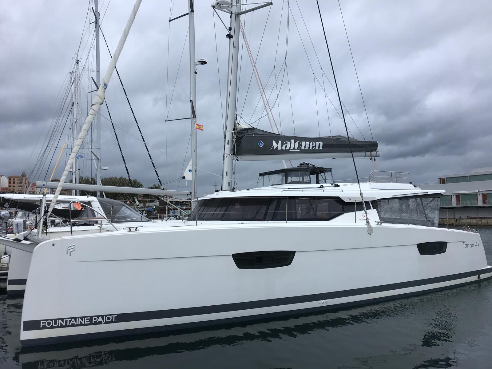 Fountaine Pajot Tanna 47 amarré sur un ras de quai en bretagne. Deux hublots de coques. Projecteur de pont