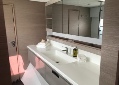 Salle de bain de la coque propriétaire à bâbord. Grande vasque simple avec douche à l'italienne et toilette séparé. Nombreux rangements et miroirs.